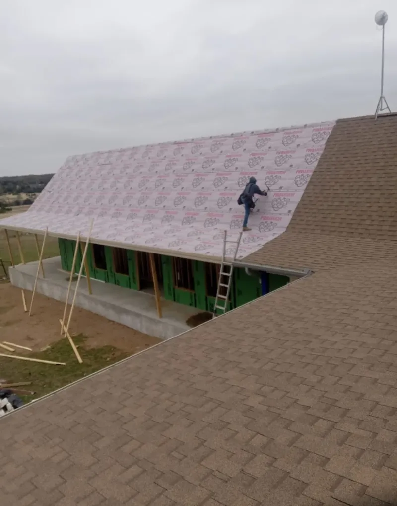Worker preparing underlayment for a metal roof installation in South Lake Tahoe